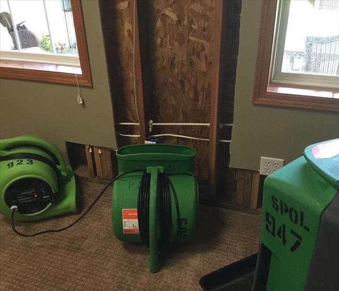 SERVPRO equipment on the floor of a room, with green walling. 