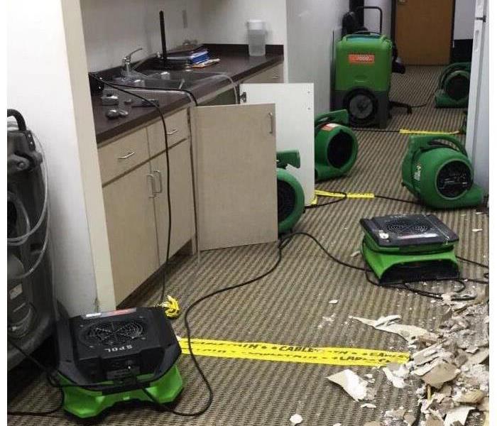 drywalling and SERVPRO equipment on the floor of an office building